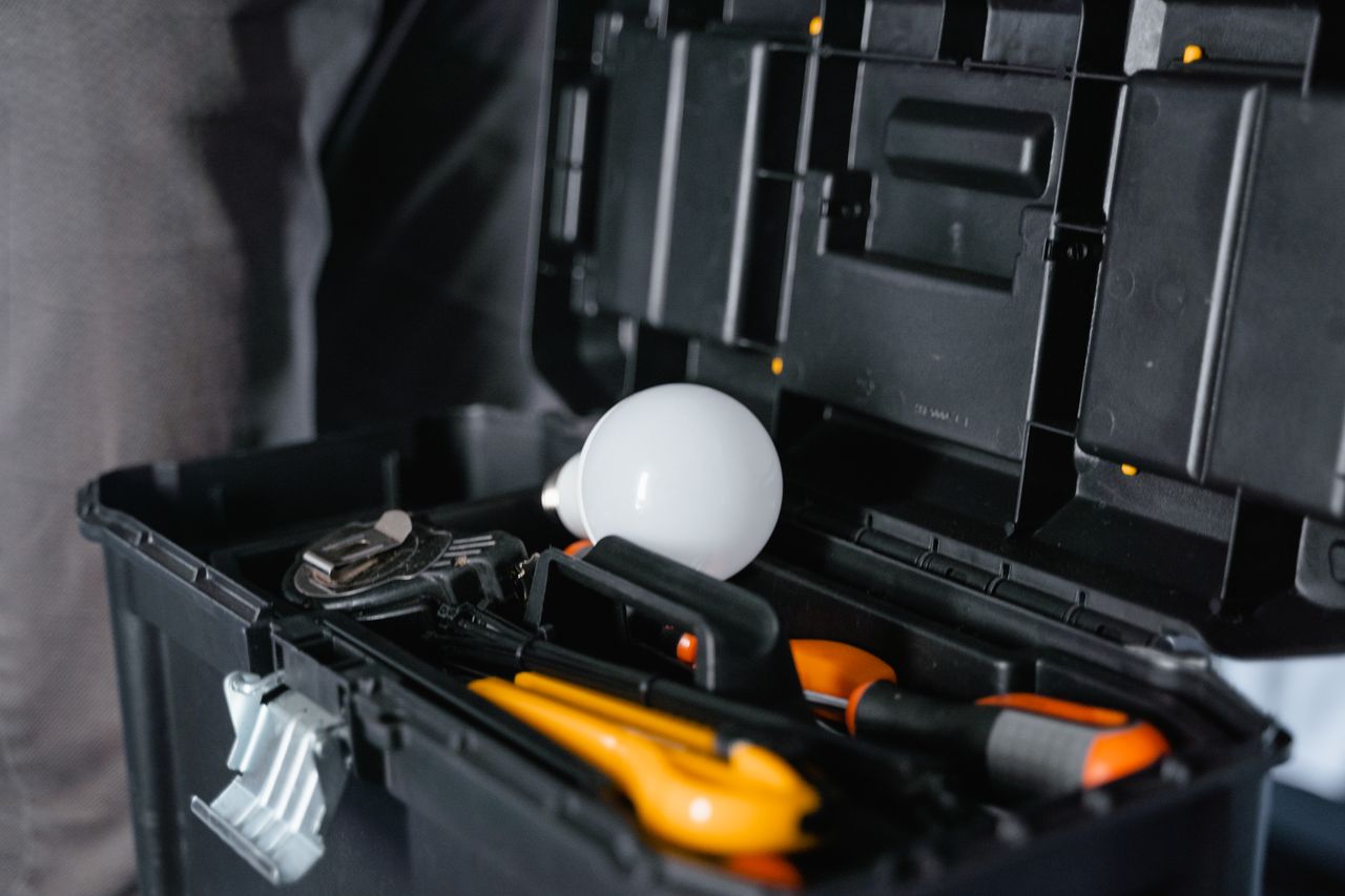 why-choose-us Open toolbox containing various tools and a light bulb.